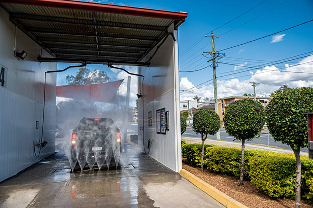water spraying upward onto car in underbody wash tunnel
